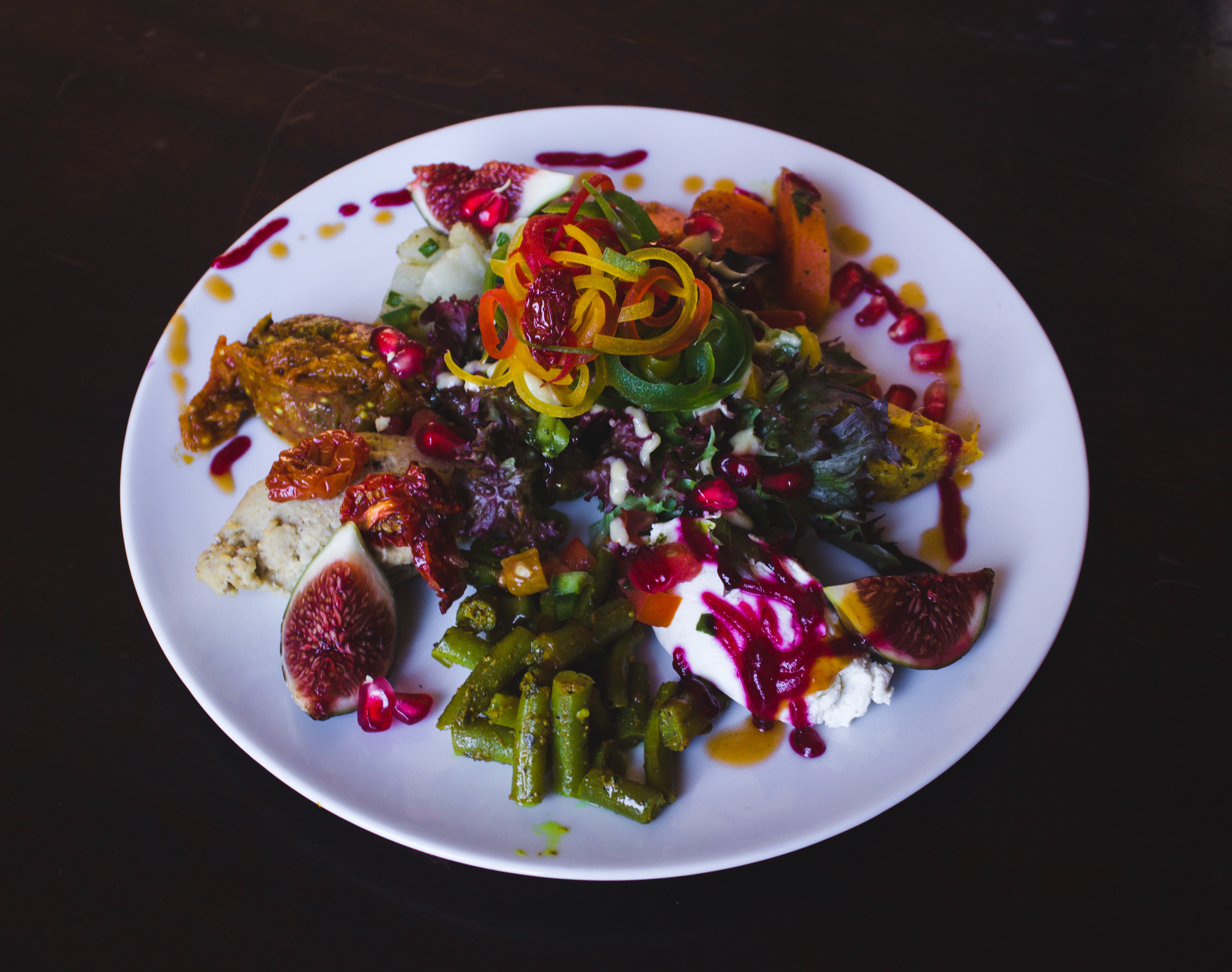 A hearty salad drizzled with purple and orange dressing